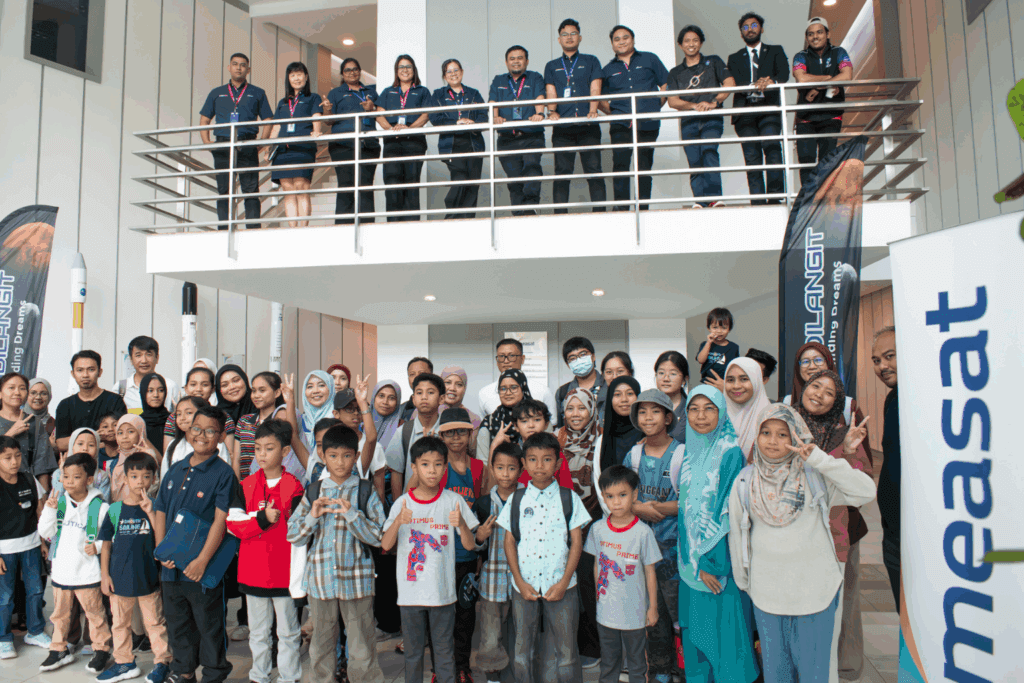 Pelajar, ibu bapa dan kakitangan bergambar beramai-ramai di bangunan MEASAT semasa program bersama Apadilangit