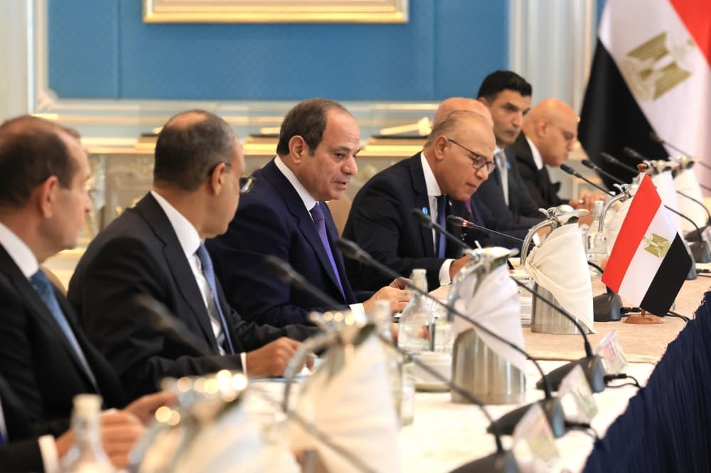 Presiden Mesir Abdel Fattah El-Sisi dalam satu mesyuarat delegasi, dengan bendera Mesir di meja