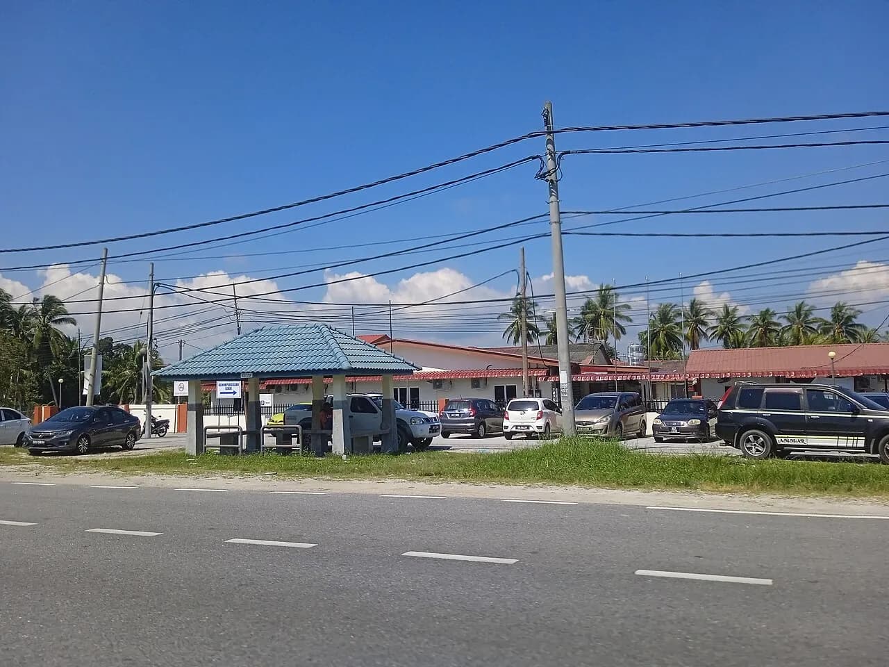 Bangunan klinik kesihatan di tepi jalan dengan kereta diletakkan di hadapannya