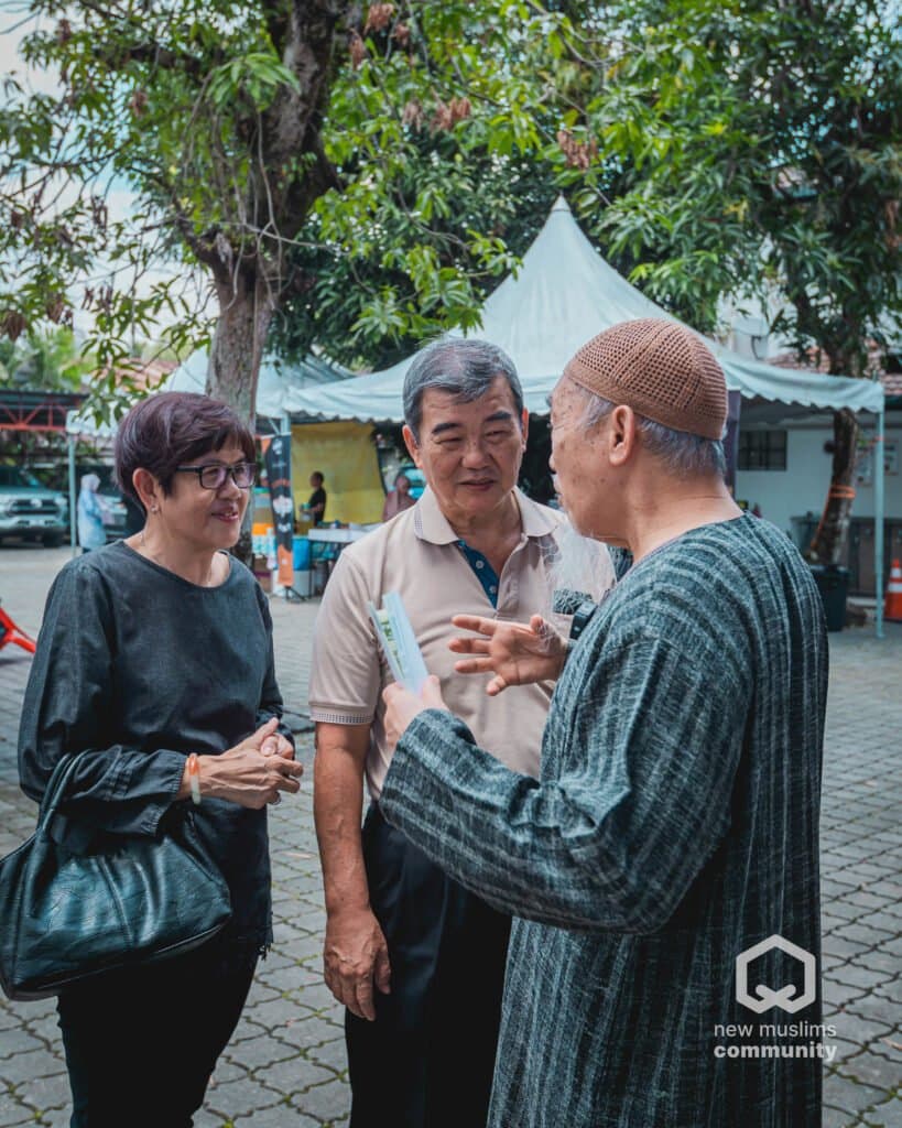 Pengunjung berbual dengan seorang warga emas di perkarangan semasa Hari Terbuka New Muslims Community sebelum ini